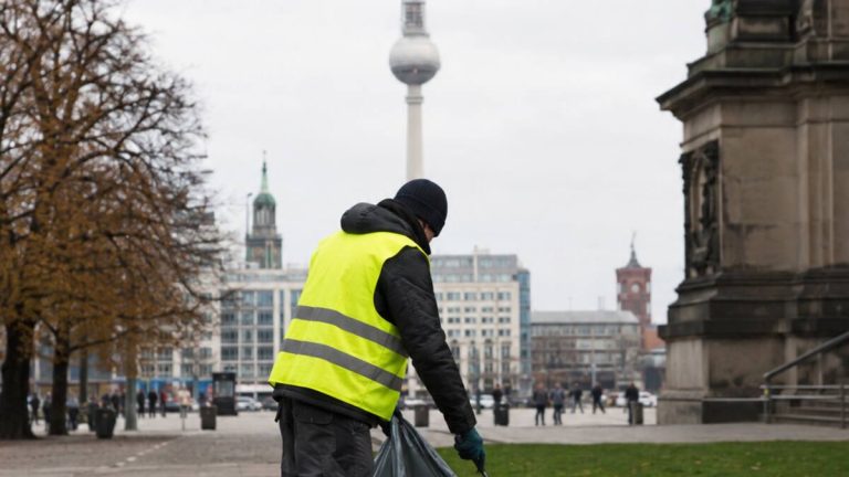 Pracownik sprzątający przestrzeń publiczną w Berlinie