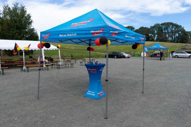 Stoisko AfD z czytelnym logo partii podczas wydarzenia w Mödlareuth