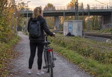 Udawał zasłabnięcie i wykorzystał seksualnie kobietę, która chciała mu pomóc. Policja w Bremie szuka czarnoskórego mężczyzny! Ilustracja AI: rowerzystka na ścieżce przy torach kolejowych w Niemczech
