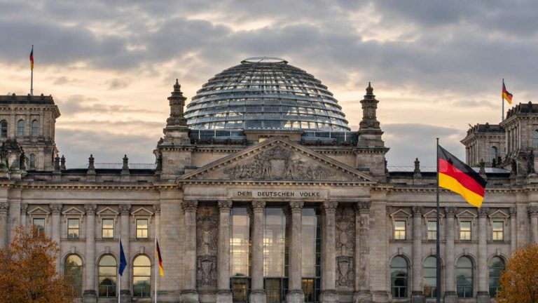 Reichstag w Berlinie z niemiecką flagą – ilustracja do wiadomości o sporze CSU i SPD