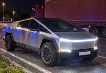 Cybertruck na polskich tablicach zatrzymany pod Monachium! Kierowca nie miał uprawnień do tak ciężkiego auta Srebrny Cybertruck nocą, z ciężarówką w tle. Symboliczna ilustracja AI.