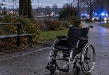 Horror w Niemczech: 18-latka miała podpalić 67-latka na wózku inwalidzkim! Pusty wózek inwalidzki w parku, w tle światła służb ratunkowych