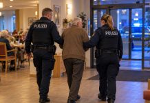 72-latek zabił 86-latkę w niemieckim domu opieki! Dwie inne seniorki ciężko ranne Ilustracja AI: policjanci eskortują starszego mężczyznę w domu opieki