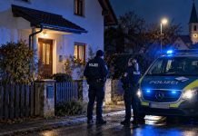 Przyszli sprawdzić, jak przechowuje broń. Właściciel miał zastrzelić pracownicę i pracownika urzędu w Bawarii! Niemieccy policjanci przed domem w Bawarii po strzelaninie podczas kontroli broni – ilustracja AI