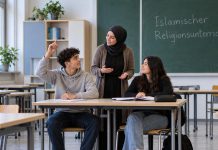 Niemieckie gimnazjum wprowadziło lekcje islamu! To pierwsza taka szkoła w regionie Heilbronn Symboliczna ilustracja lekcji religii islamskiej: fikcyjna nauczycielka rozmawia z uczniami, jeden z nich podnosi rękę.