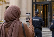 Somalijska influencerka nawoływała do przemocy na TikToku. Sąd w Niemczech pozwolił na jej deportację! Ilustracja AI: kobieta widziana od tyłu nagrywa telefonem przed sądem; w tle policjanci. Nie przedstawia rzeczywistej influencerki.