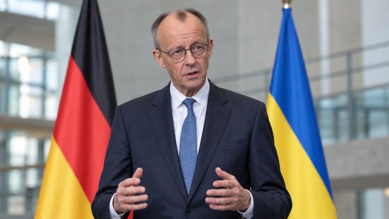 Ilustracja AI: Friedrich Merz w garniturze, w tle flagi Niemiec i Ukrainy