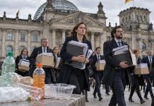 Rząd Niemiec planuje dwa nowe podatki i ponad 1000 etatów! Koszt: 74 mln euro rocznie Urzędnicy z dokumentami przed Reichstagiem; ilustracja nowych podatków od napojów z cukrem i plastiku