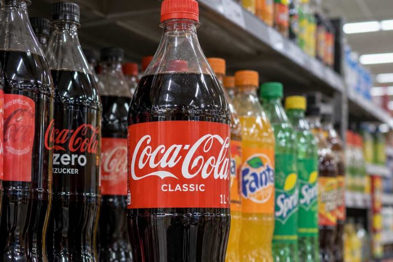 Butelki Coca-Coli i innych słodzonych napojów na półce w niemieckim supermarkecie