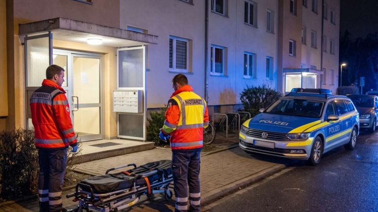 Nocna interwencja ratowników i policji przed blokiem mieszkalnym — ilustracja AI