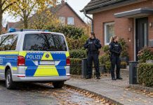 Niemcy: Po ataku autem na grupę ludzi policja chroni rodziny uczestników zajścia! Symboliczna ilustracja AI: policjanci i radiowóz przed domem; nie jest to dokumentacja zdarzenia w Neustadt.