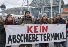 Niemcy chcą przyspieszyć deportacje! Około 900 osób protestowało przeciwko nowemu terminalowi na lotnisku w Monachium Demonstranci z transparentem przeciw terminalowi do deportacji — ilustracja AI