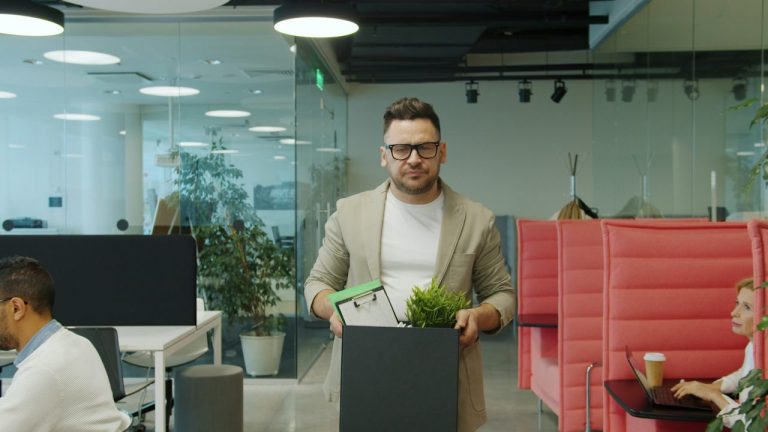 Pracownik opuszczający biuro z kartonem po redukcji etatu