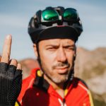 Rowerzysta pokazuje środkowy palec