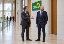 Niemcy: Zieloni chcą zakazać posłom CDU nawet mówienia „dzień dobry” do AfD! Symboliczna ilustracja parlamentarnego powitania przy logo Zielonych; fikcyjne postacie