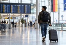 Unijny fundusz na dobrowolne powroty migrantów jest pusty! W Niemczech wstrzymano już część wyjazdów Podróżny z walizką na niemieckim lotnisku — ilustracja AI