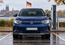 Ryzyko pożaru! VW wzywa do serwisów ponad 70 tys. aut elektrycznych Ilustracja AI: Volkswagen ID.4 przy ładowarce na zewnątrz, z widocznym logo VW i niemiecką flagą.