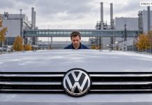 Volkswagen ma 5,82 miliarda euro straty za jeden kwartał! Symboliczna ilustracja AI: fikcyjny pracownik za samochodem Volkswagen na tle zakładu
