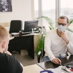 mężczyźni w maseczkach w biurze
